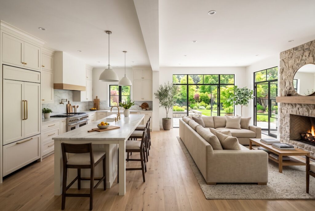 Wide view of an open-concept kitchen flowing into the family room, with a clean structural beam where a wall was removed